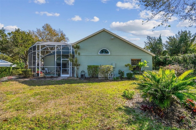 rear view of property featuring a lanai and a lawn