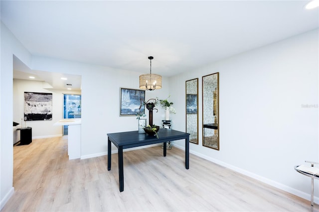 home office with a chandelier and light wood-type flooring