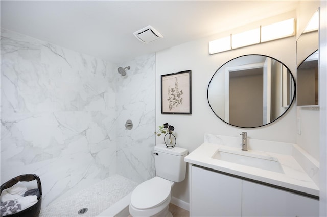 bathroom with vanity, a tile shower, and toilet