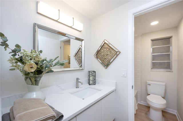 bathroom featuring vanity, toilet, and hardwood / wood-style floors