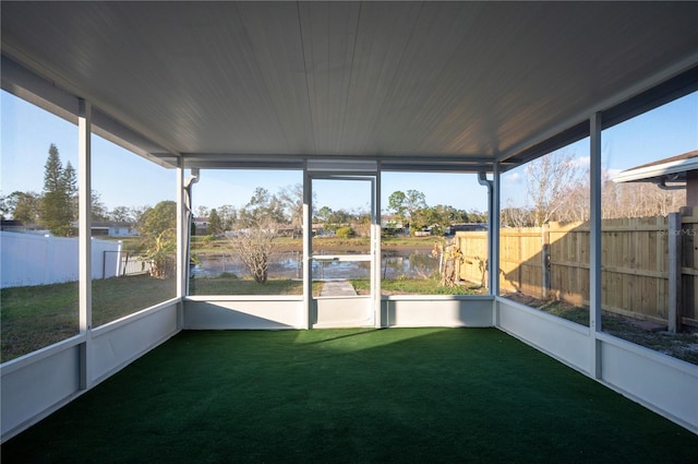 unfurnished sunroom featuring a water view