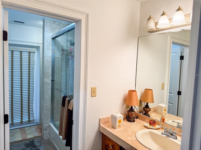 bathroom with vanity and combined bath / shower with glass door