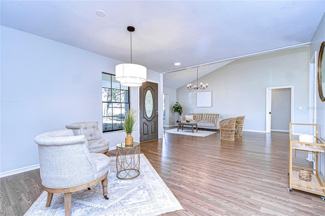 interior space featuring an inviting chandelier, lofted ceiling, and wood-type flooring