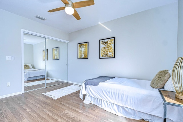 bedroom with wood-type flooring, ceiling fan, and a closet