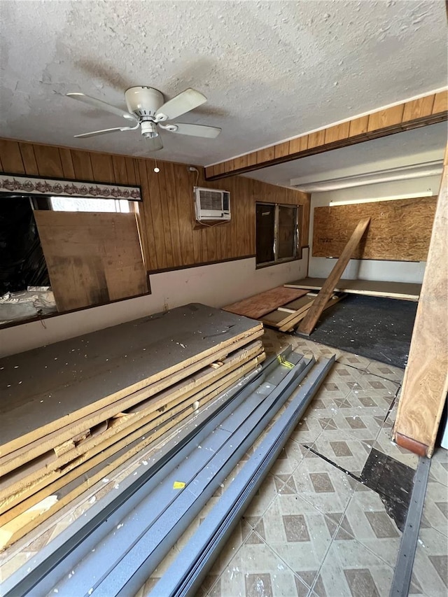 miscellaneous room featuring a wall mounted air conditioner, a textured ceiling, and wood walls