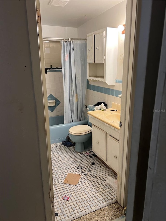 full bathroom featuring toilet, tile walls, vanity, shower / bath combo, and tile patterned flooring