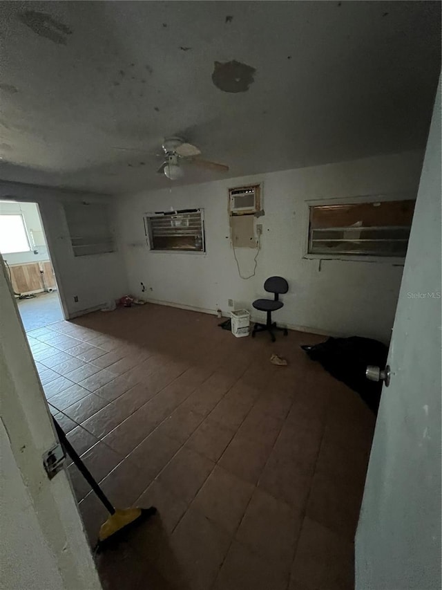 unfurnished room featuring ceiling fan, wood-type flooring, and a wall unit AC