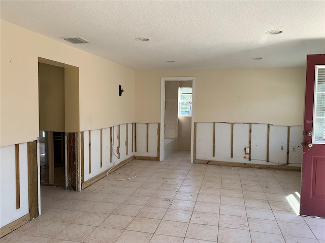 unfurnished room with a textured ceiling