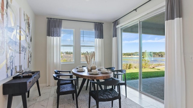 dining room with a water view and a wealth of natural light