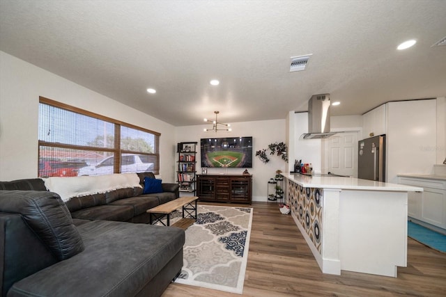 living room featuring a notable chandelier, a textured ceiling, and dark hardwood / wood-style flooring