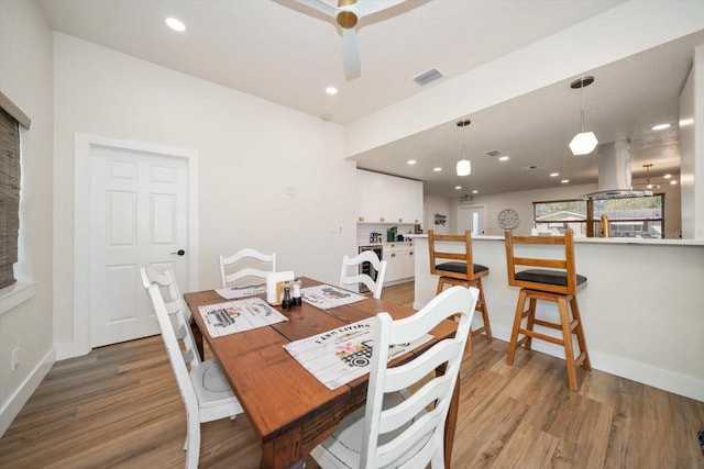 dining area with wood-type flooring and ceiling fan