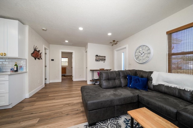 living room featuring wood-type flooring and a textured ceiling