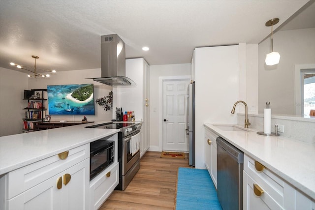 kitchen with pendant lighting, island range hood, white cabinets, and appliances with stainless steel finishes