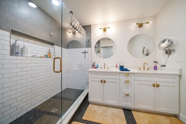 bathroom with walk in shower, tile patterned floors, vanity, and a textured ceiling