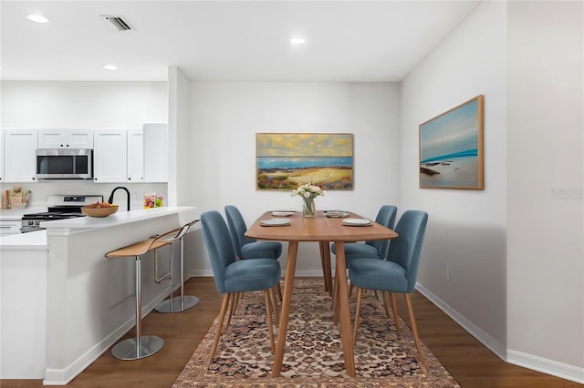 dining room with sink and dark wood-type flooring