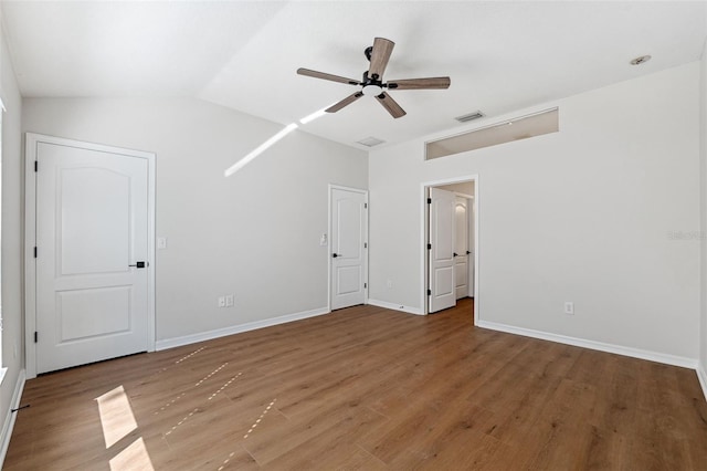 unfurnished bedroom with hardwood / wood-style flooring, ceiling fan, and vaulted ceiling