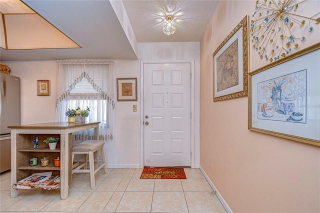 tiled foyer entrance with a textured ceiling