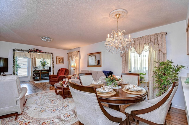 dining area featuring hardwood / wood-style flooring, a chandelier, and a textured ceiling