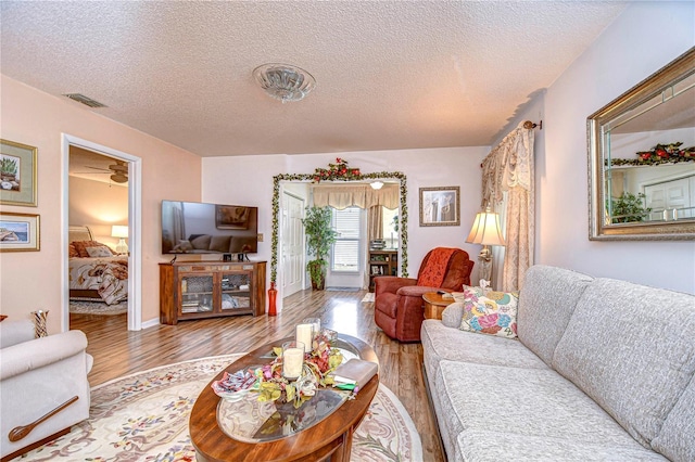 living room featuring a textured ceiling and light wood-type flooring