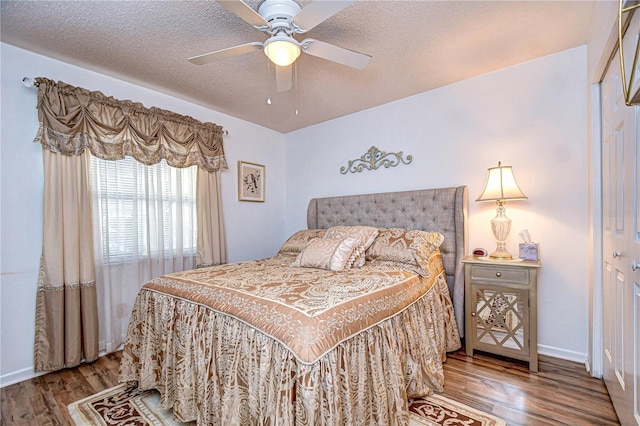 bedroom featuring ceiling fan, wood-type flooring, and a textured ceiling