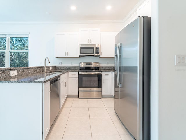 kitchen with light tile patterned flooring, white cabinetry, sink, ornamental molding, and stainless steel appliances