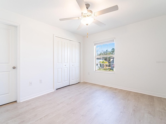 unfurnished bedroom with ceiling fan, a closet, and light wood-type flooring