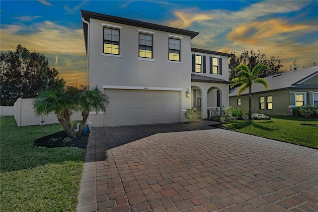 view of front of house featuring a garage and a lawn