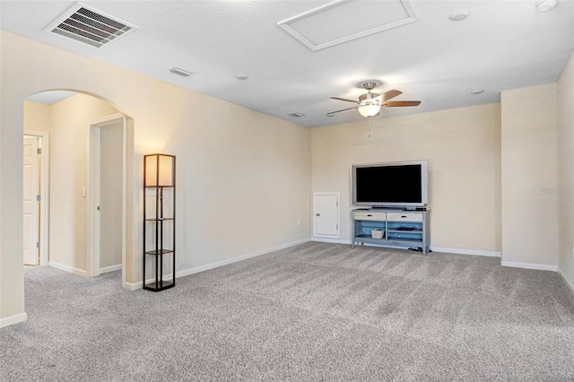 unfurnished living room with light colored carpet, a textured ceiling, and ceiling fan