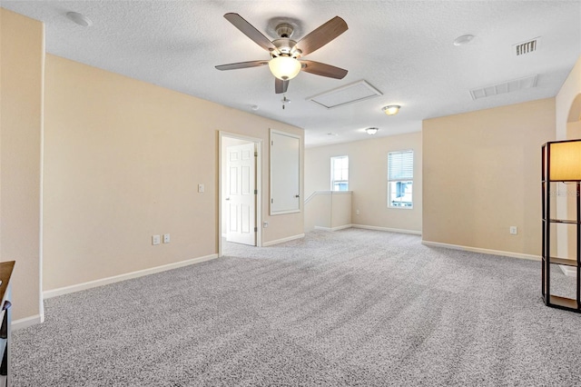 carpeted spare room featuring ceiling fan and a textured ceiling