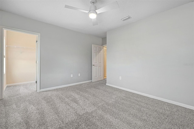 carpeted empty room featuring ceiling fan