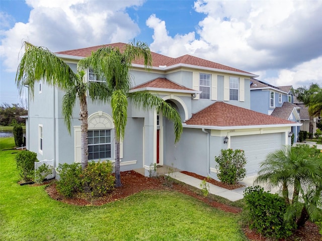 mediterranean / spanish-style home featuring a garage and a front lawn