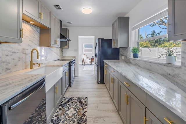 kitchen with backsplash, appliances with stainless steel finishes, sink, and gray cabinetry