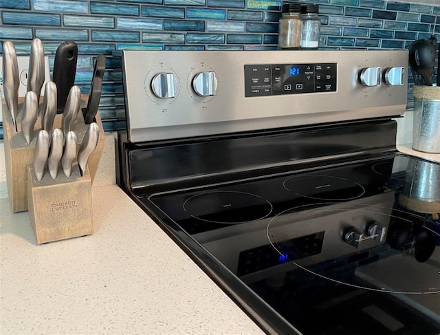 details featuring tasteful backsplash and stainless steel electric range oven