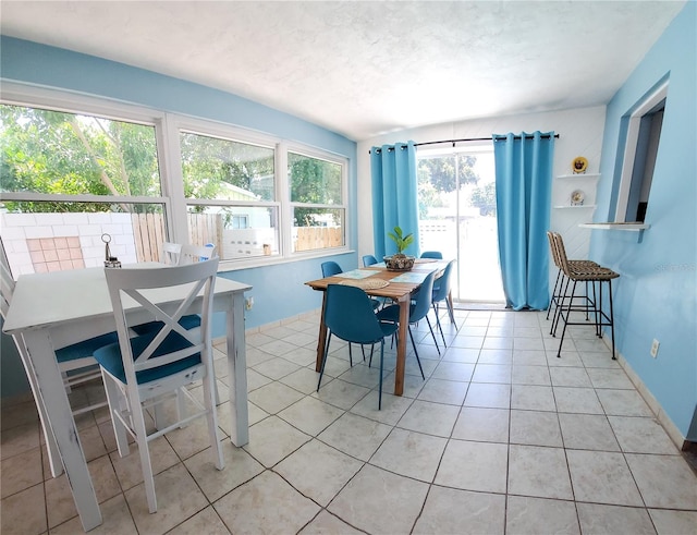 tiled dining space with a textured ceiling