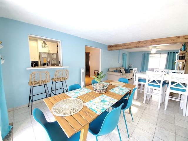 tiled dining room with beamed ceiling