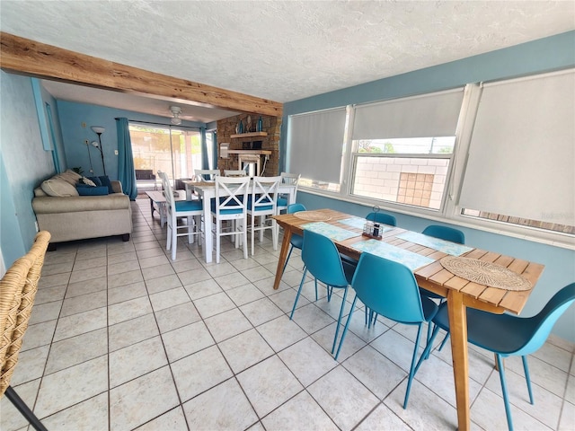 dining room featuring a textured ceiling, light tile patterned floors, and beam ceiling