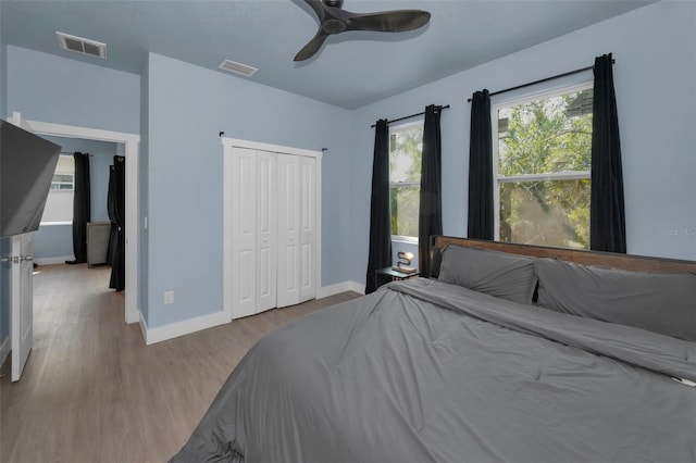 bedroom featuring ceiling fan, light hardwood / wood-style floors, and a closet