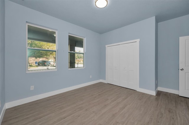 unfurnished bedroom with wood-type flooring and a closet