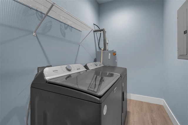 clothes washing area featuring light hardwood / wood-style floors, washer and clothes dryer, electric panel, and water heater