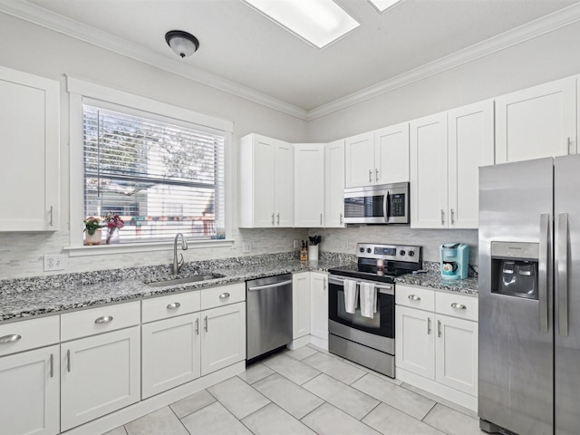 kitchen featuring white cabinetry, stainless steel appliances, light stone countertops, sink, and backsplash