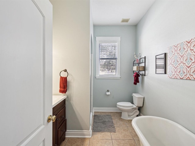 bathroom with vanity, toilet, tile patterned floors, and a tub to relax in