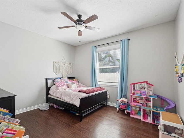 bedroom featuring dark hardwood / wood-style flooring, ceiling fan, and a textured ceiling