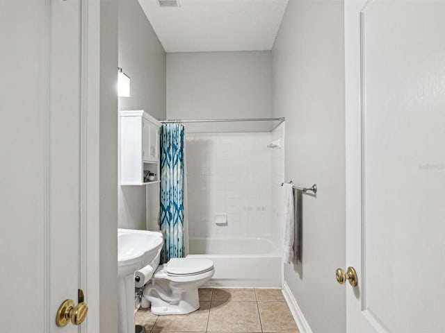 bathroom featuring shower / bath combo with shower curtain, tile patterned flooring, and toilet