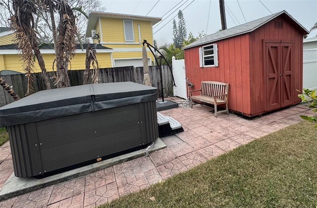 view of patio featuring a hot tub and a storage unit