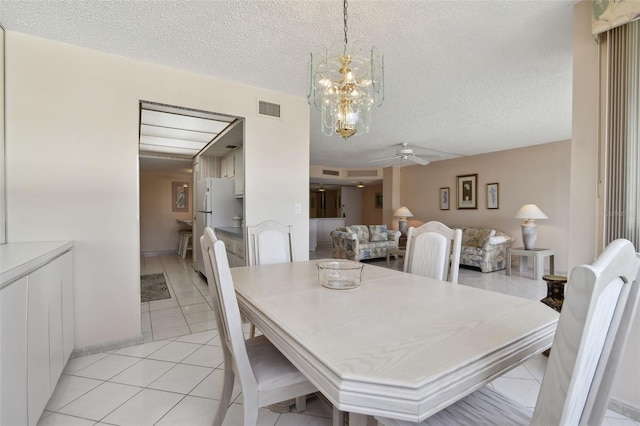 tiled dining room with a textured ceiling and ceiling fan