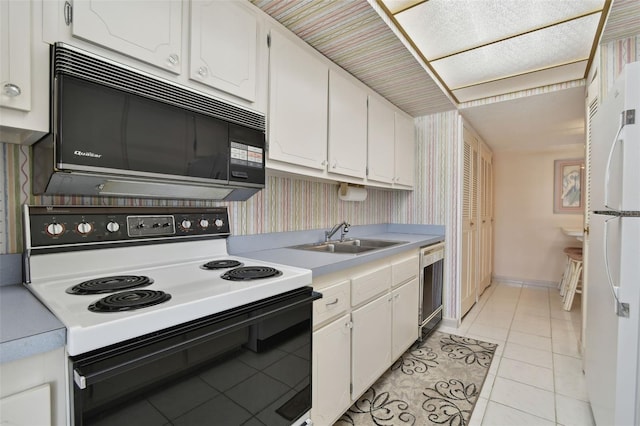 kitchen with dishwasher, sink, white cabinets, light tile patterned floors, and electric stove