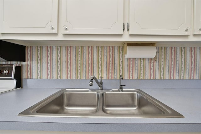 interior details featuring sink and white cabinets