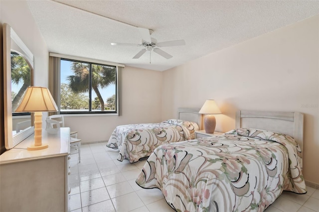 bedroom with ceiling fan, a textured ceiling, and light tile patterned floors