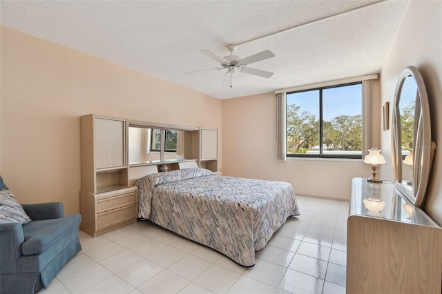 bedroom featuring light tile patterned flooring, ceiling fan, and a textured ceiling