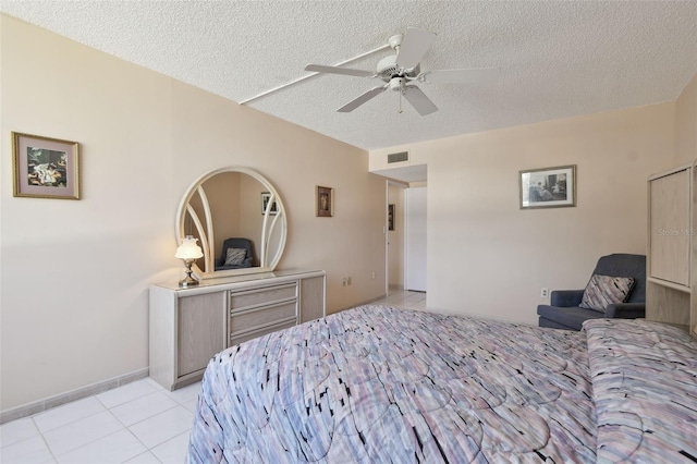 tiled bedroom with ceiling fan and a textured ceiling